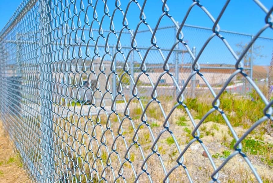 Galvanized chain link fence at dusk